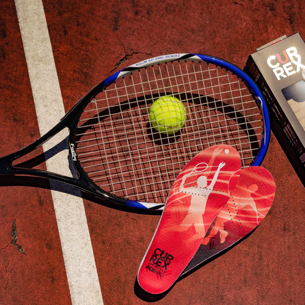 Pair of red low profile CURREX ACEPRO insoles sitting on tennis court next to tennis ball and racquet #1-wahle-dein-profil_low