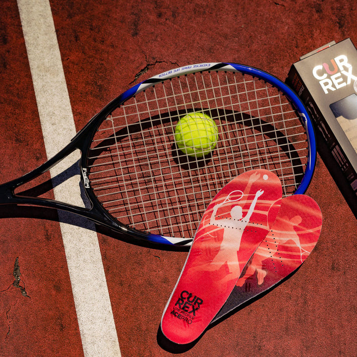 Pair of red low profile CURREX ACEPRO insoles sitting on tennis court next to tennis ball and racquet #1-wahle-dein-profil_low