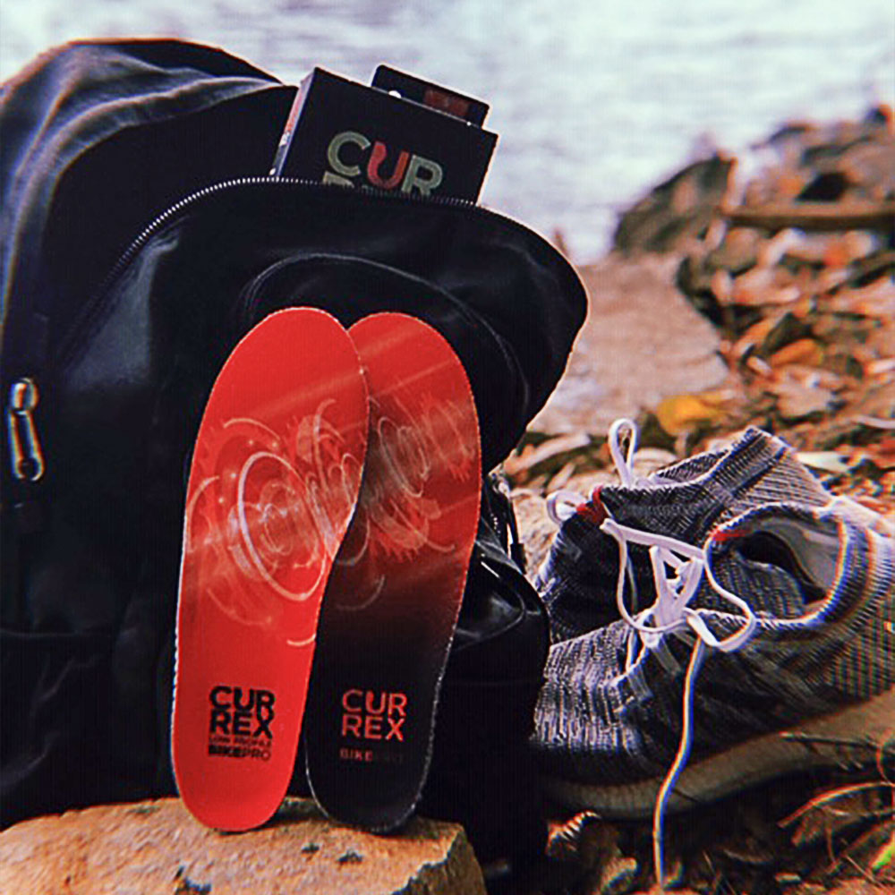 CURREX HIKEPRO red low profile insoles sitting next to hiking shoes and backpack near river #1-wahle-dein-profil_low