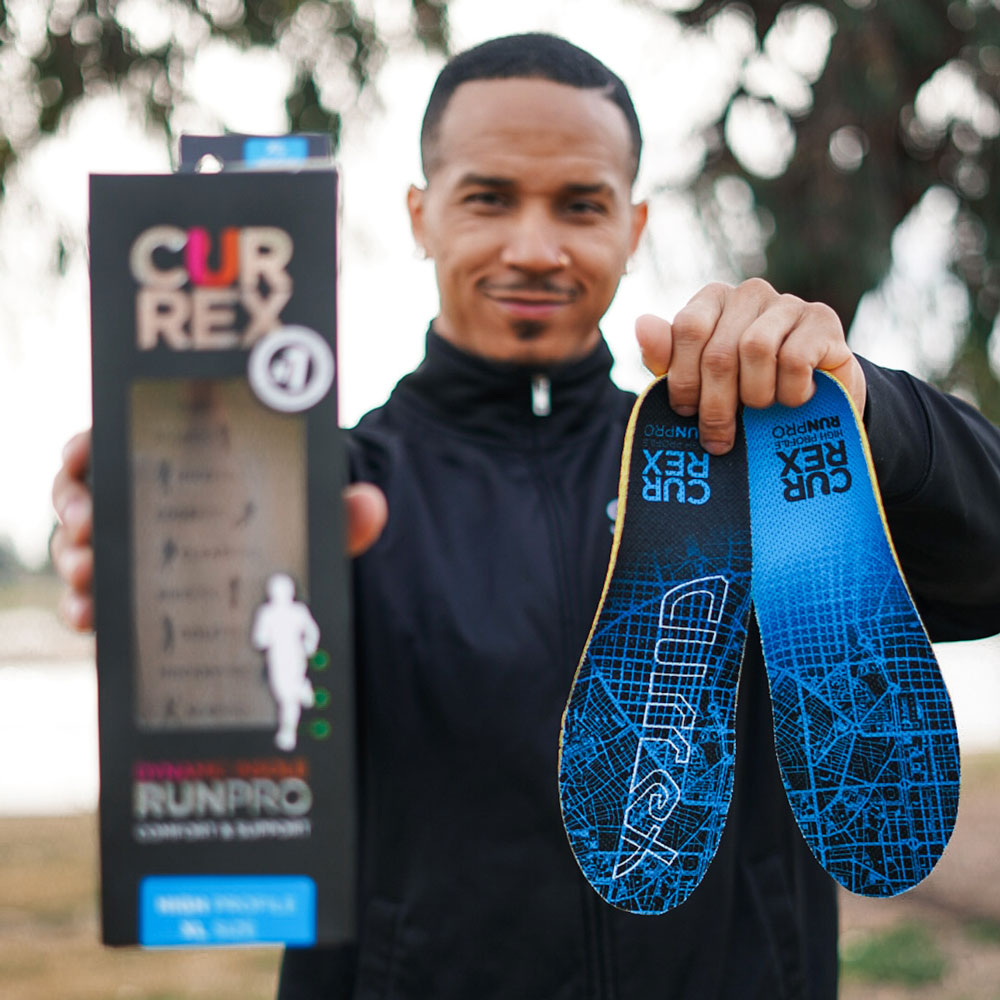 Man holding up a pair of blue high profile CURREX RUNPRO insoles #1-wahle-dein-profil_high