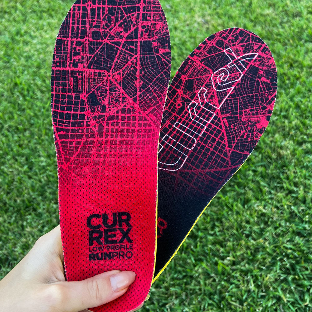 Woman holding up a pair of red low profile CURREX RUNPRO insoles #1-wahle-dein-profil_low